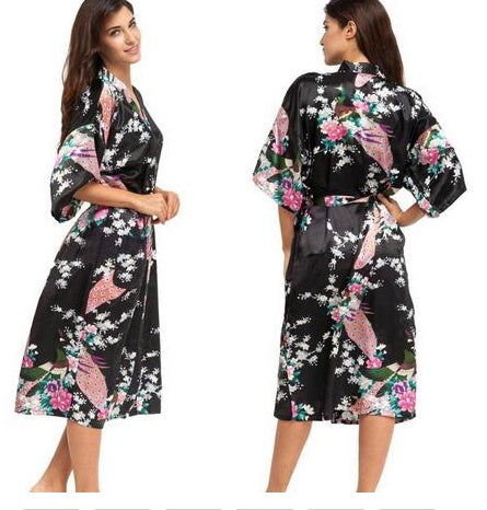 Woman wearing a black floral kimono-style robe with pink butterflies and flowers.